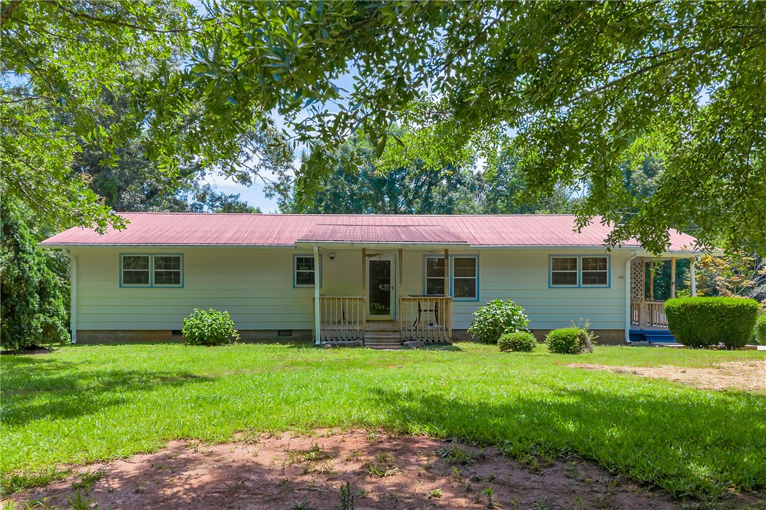 A classic ranch home nestled among mature trees with a welcoming front porch.
