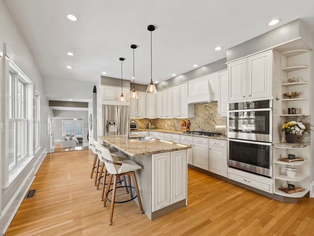 20 Maple Street Lexington, MA 02420 - Photo 11 of 36 a kitchen with stainless steel appliances granite countertop a stove a sink a refrigerator and white cabinets with wooden floor