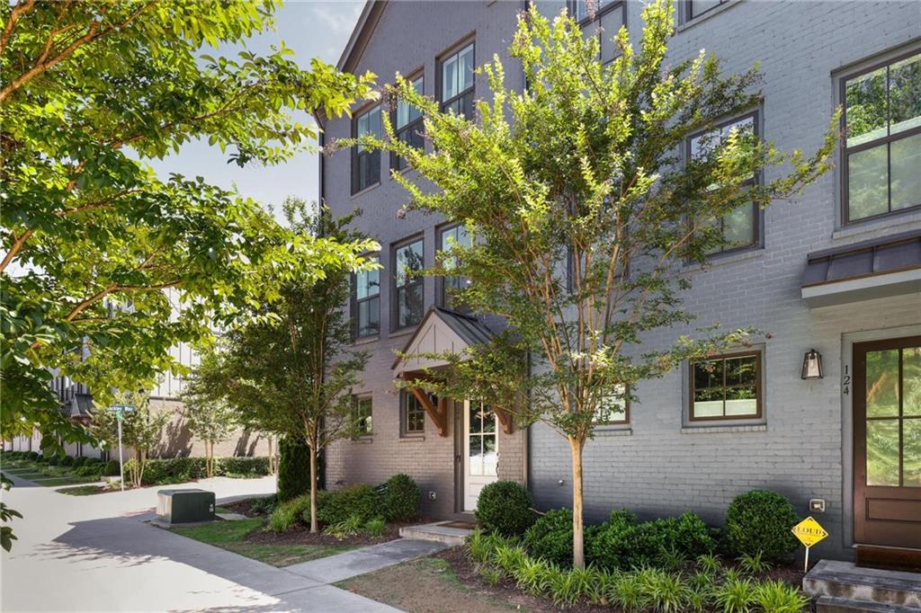 a view of a brick house with a tree and plants