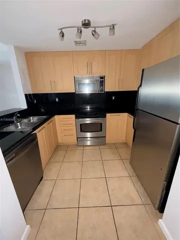 a kitchen with a sink a stove and cabinets