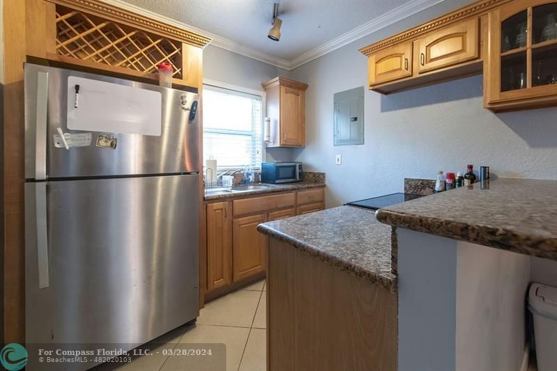 a kitchen with stainless steel appliances granite countertop a refrigerator a sink and a cabinets