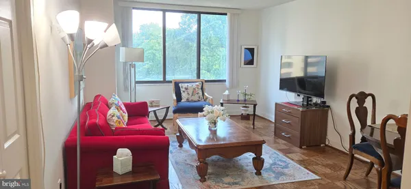 a living room with furniture a flat screen tv and a large window