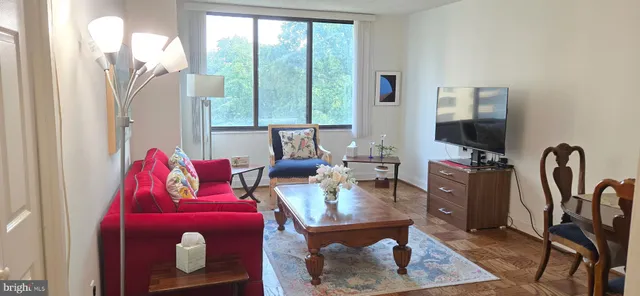 a living room with furniture a flat screen tv and a large window