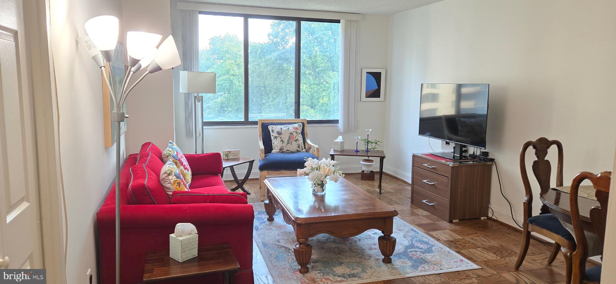 5225 Pooks Hill Road, Unit 703N Bethesda, MD 20814 - Photo 1 of 57 a living room with furniture a flat screen tv and a large window