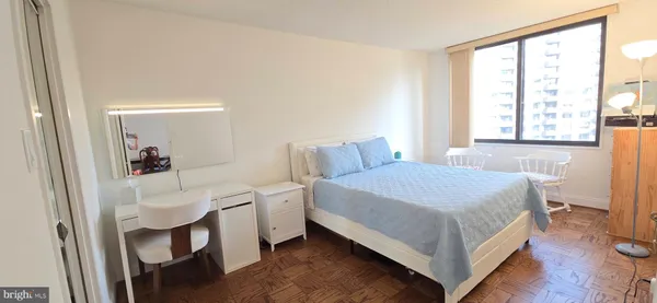 a bedroom with a bed and a large window