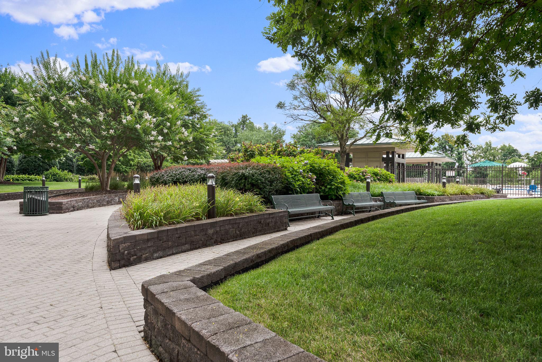 5225 Pooks Hill Road, Unit 703N Bethesda, MD 20814 - Photo 47 of 57 a view of a garden with a bench in front of the house