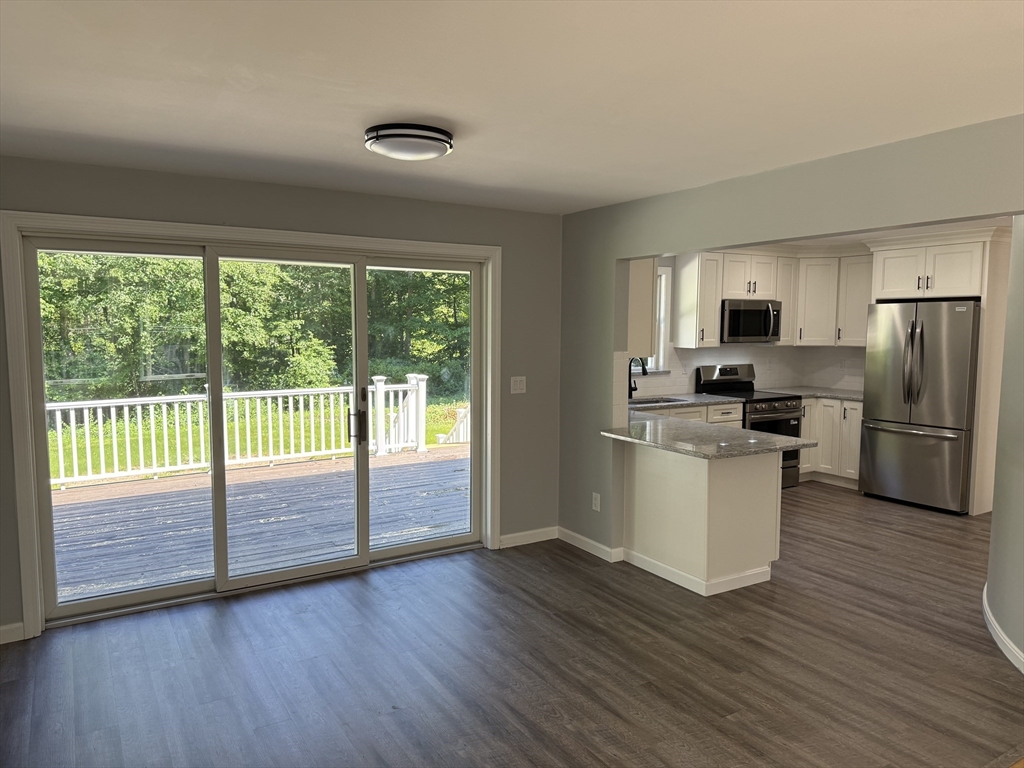 295 Frenchtown Road East Greenwich, RI 02818 - Photo 7 of 26 a kitchen with wooden floors white cabinets and stainless steel appliances