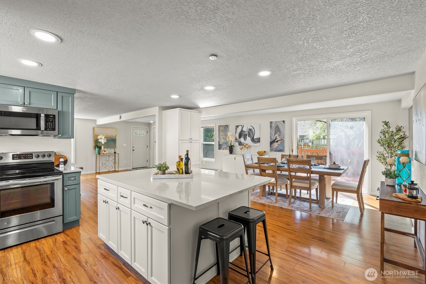 8109 15th Avenue Southwest Seattle, WA 98106 - Photo 8 of 39 a open kitchen with stainless steel appliances granite countertop a stove top oven a sink dishwasher a dining table and chairs with wooden floor