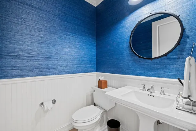 a bathroom with a toilet a sink and mirror