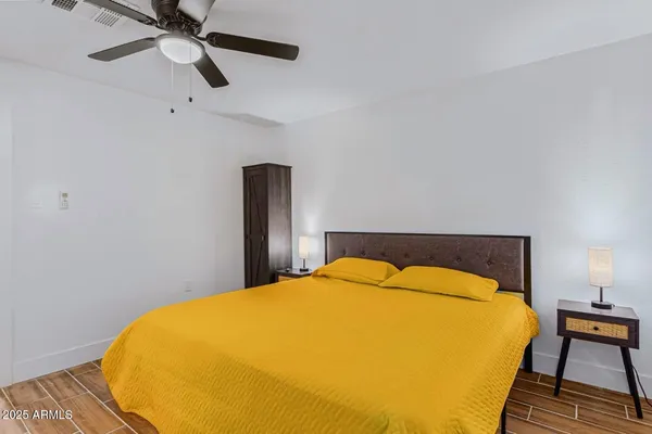 a bedroom with a bed and wooden floor