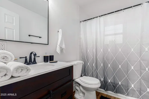 a bathroom with a sink a toilet and a mirror
