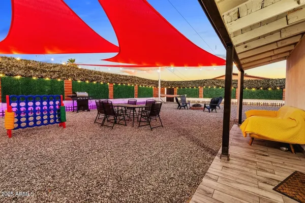 a view of a patio with a table chairs and a yard