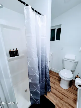 a bathroom with a toilet and a shower