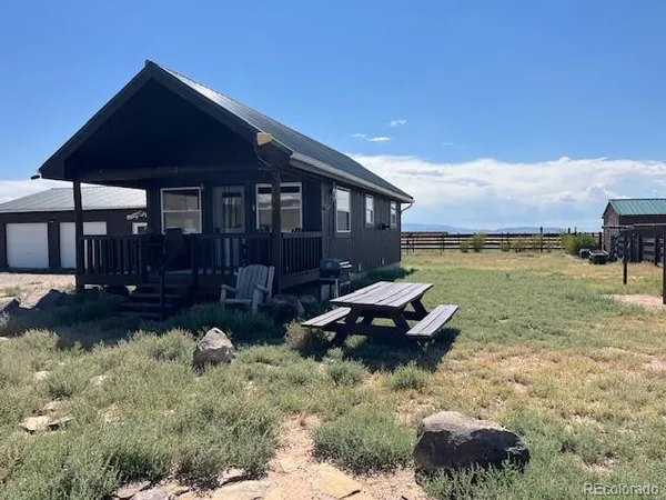 a backyard of a house with yard table and chairs