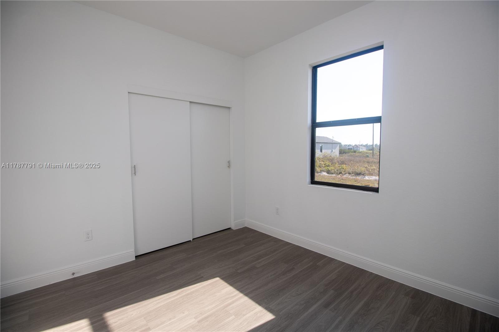 9023 Meadow Circle LaBelle, FL 33935 - Photo 19 of 35 an empty room with wooden floor and windows