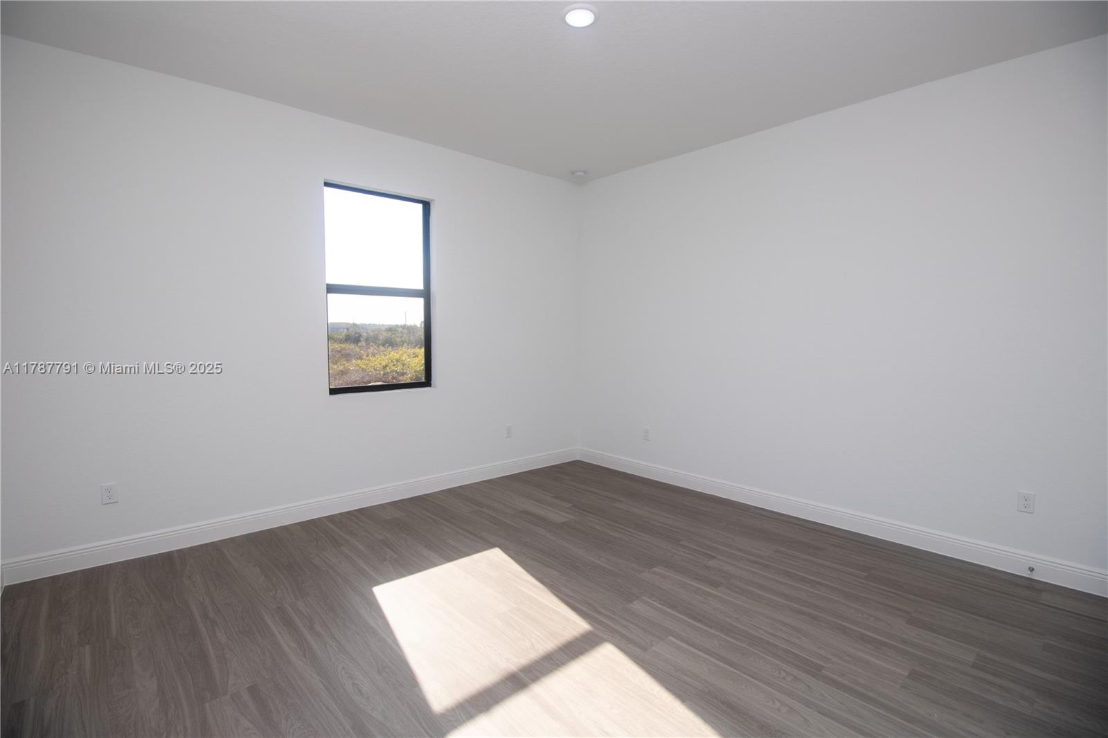 9023 Meadow Circle LaBelle, FL 33935 - Photo 26 of 35 an empty room with wooden floor and windows