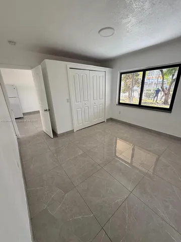 an empty room with windows and entrance