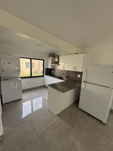 a view of a kitchen with furniture and wooden floor