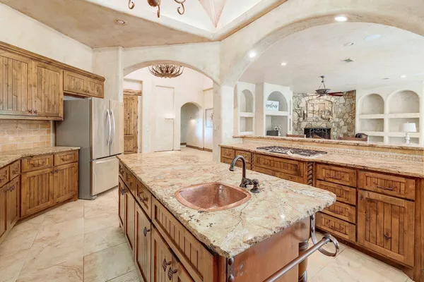 a kitchen with a stove a sink a refrigerator and wooden cabinets