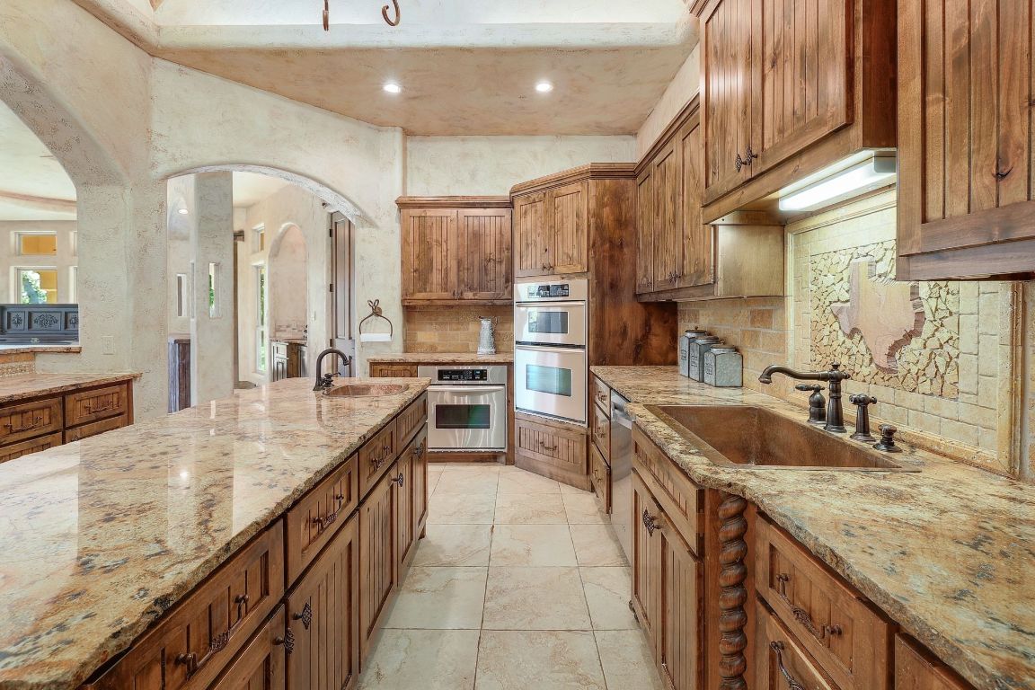 1120 Redbird Road Granger, TX 76530 - Photo 14 of 40 a large kitchen with granite countertop a sink and cabinets