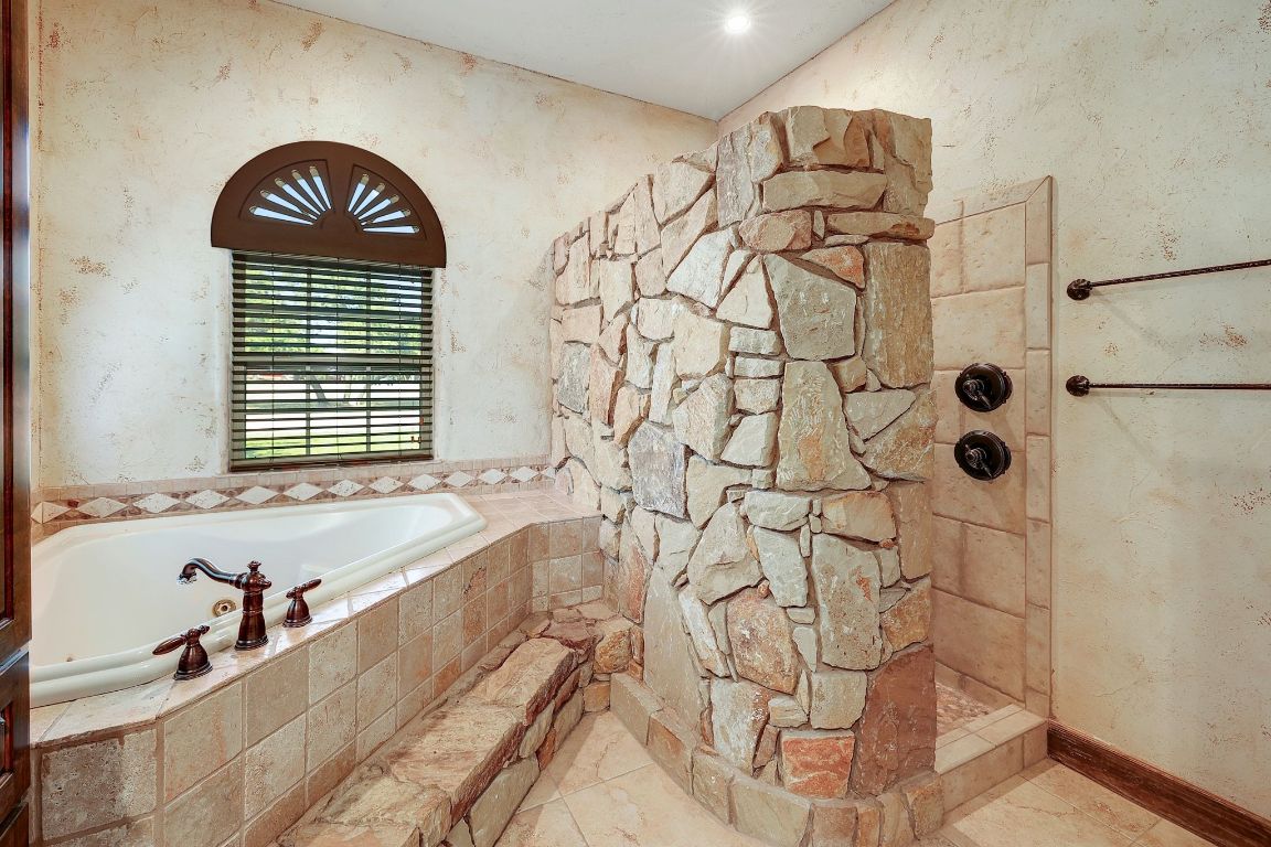 1120 Redbird Road Granger, TX 76530 - Photo 20 of 40 Bathroom featuring a garden tub, a walk in shower, and wallpapered walls