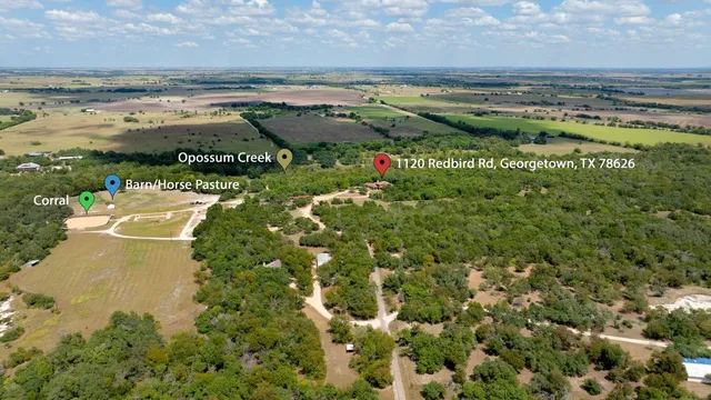 an aerial view of a house with a garden and lake view