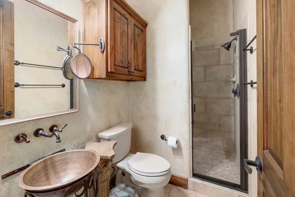 a bathroom with a toilet sink a mirror and shower