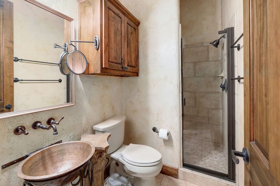 1120 Redbird Road Granger, TX 76530 - Photo 22 of 40 a bathroom with a toilet sink a mirror and shower