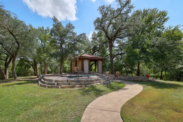 a view of a house with backyard and trees