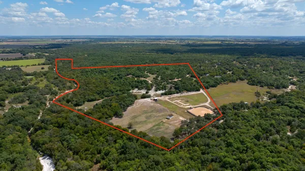 an aerial view of a house with a garden and lake view