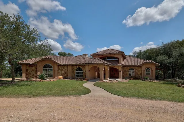 a view of a dining room with furniture a chandelier and large windows
