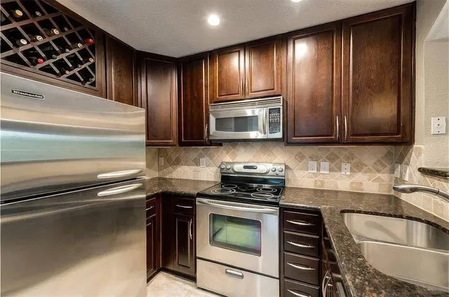a kitchen with granite countertop stainless steel appliances and cabinets