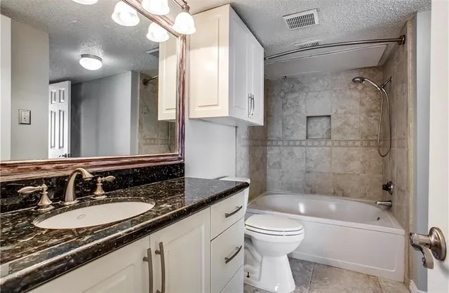 a bathroom with a granite countertop sink toilet and shower