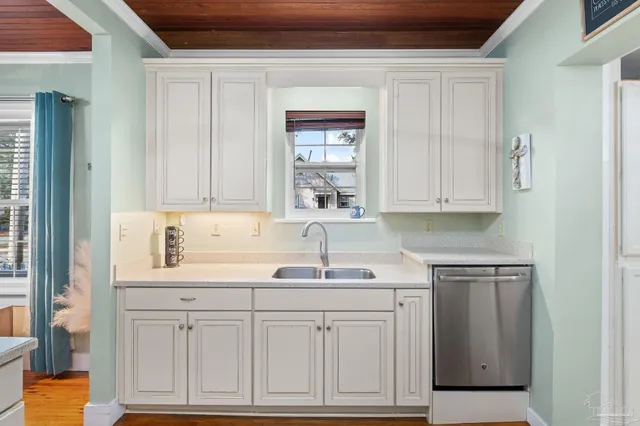 a kitchen with white cabinets and sink