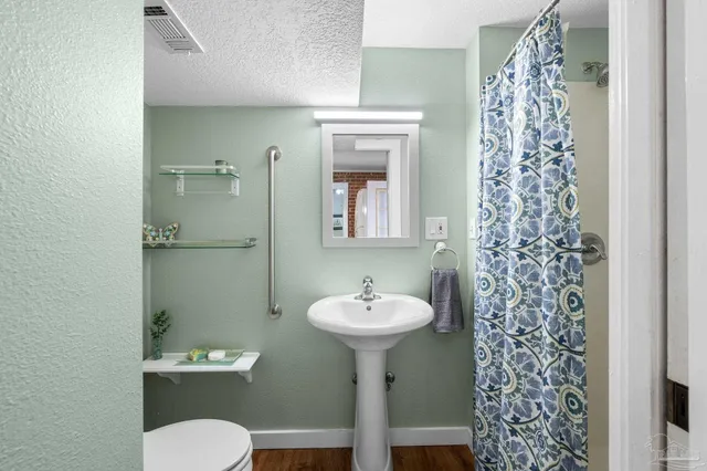 a bathroom with a sink toilet and a mirror