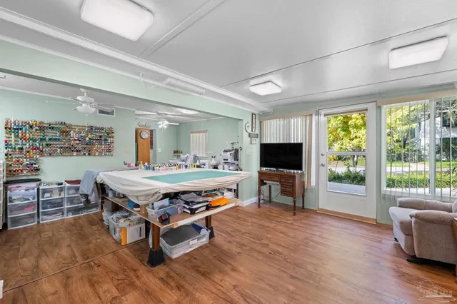a living room with furniture a flat screen tv and a large window