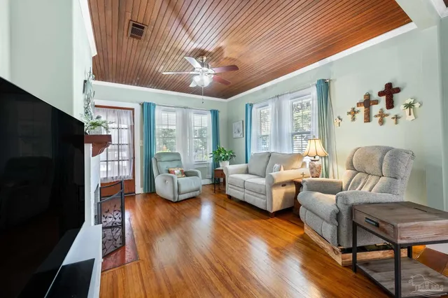 a living room with furniture fireplace and wooden floor