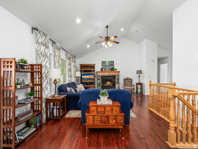 1602 Renaissance Way Springville, UT 84663 - Photo 8 of 42 Vaulted ceiling living room featuring wood-finish flooring, a stone fireplace with a wood mantel, and a wooden staircase with balusters