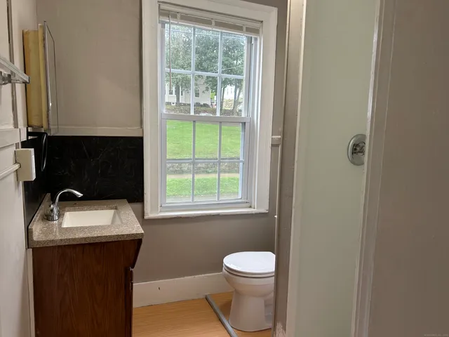 a bathroom with a sink toilet and window