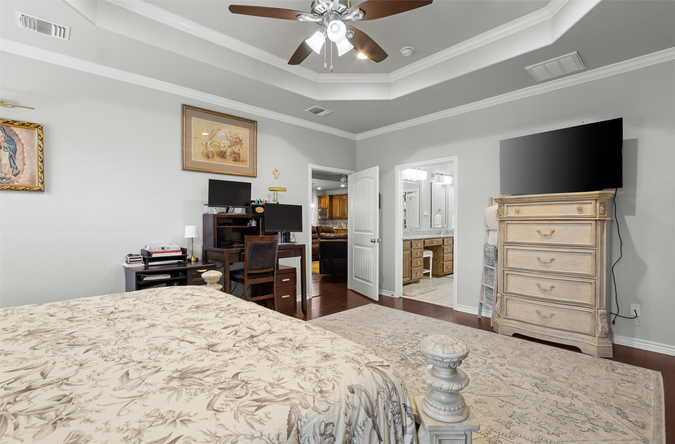16017 Toby Court Temple, TX 76502 - Photo 14 of 33 Bedroom featuring a raised ceiling, a ceiling fan, dark wood-type flooring, ornamental molding, and connected bathroom