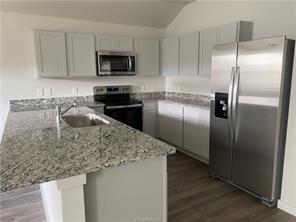 6022 Eagle Ridge Drive Bryan, TX 77807 - Photo 2 of 11 a kitchen with stainless steel appliances granite countertop a refrigerator a stove a sink and a granite counter tops