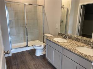 6022 Eagle Ridge Drive Bryan, TX 77807 - Photo 4 of 11 a bathroom with a granite countertop sink toilet and shower