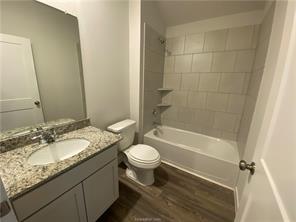 6022 Eagle Ridge Drive Bryan, TX 77807 - Photo 7 of 11 a bathroom with a granite countertop sink toilet mirror and shower