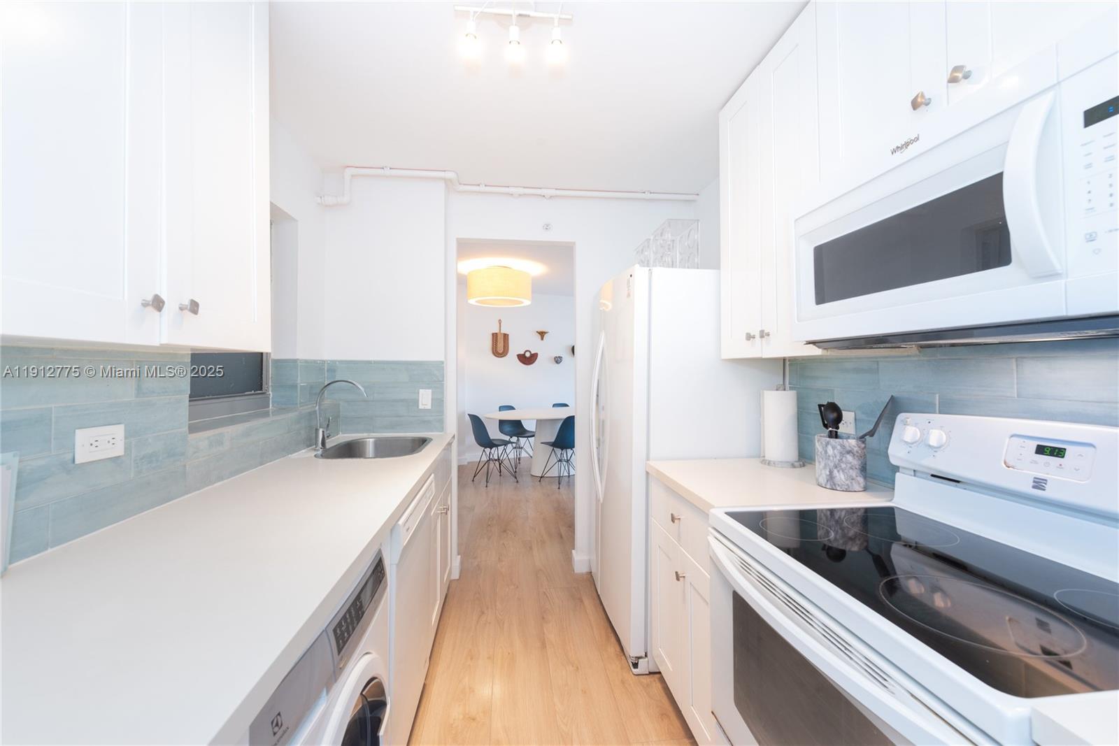 1881 Washington Avenue, Unit 3D Miami Beach, FL 33139 - Photo 17 of 30 a kitchen with stainless steel appliances a stove a sink and white cabinets