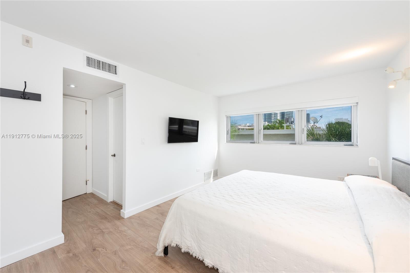 1881 Washington Avenue, Unit 3D Miami Beach, FL 33139 - Photo 8 of 30 a bedroom with a bed and a window