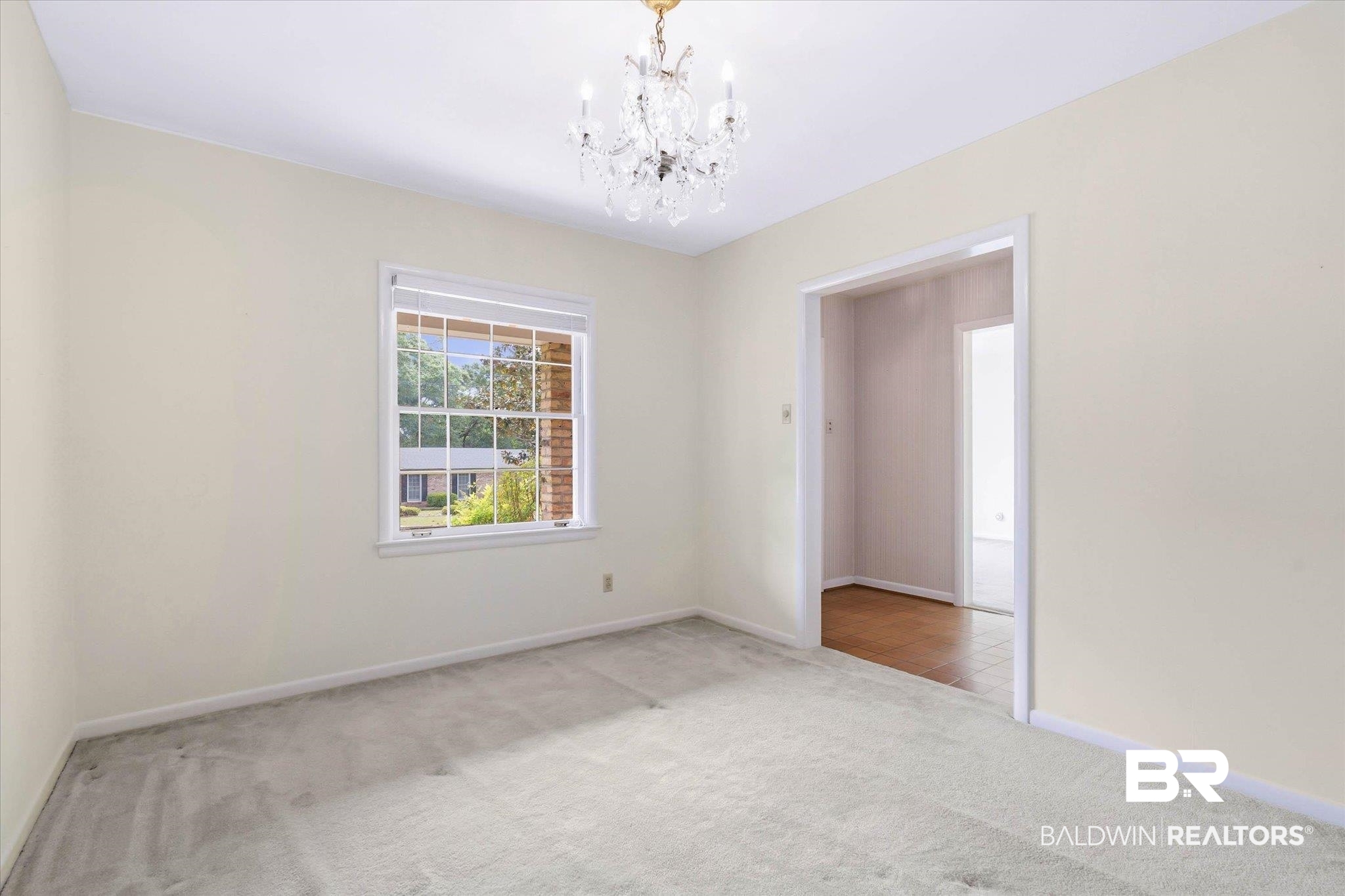 1182 Ginger Drive Mobile, AL 36693 - Photo 8 of 37 Room with light-colored carpeting, a window featuring a white frame and blinds, and a crystal chandelier