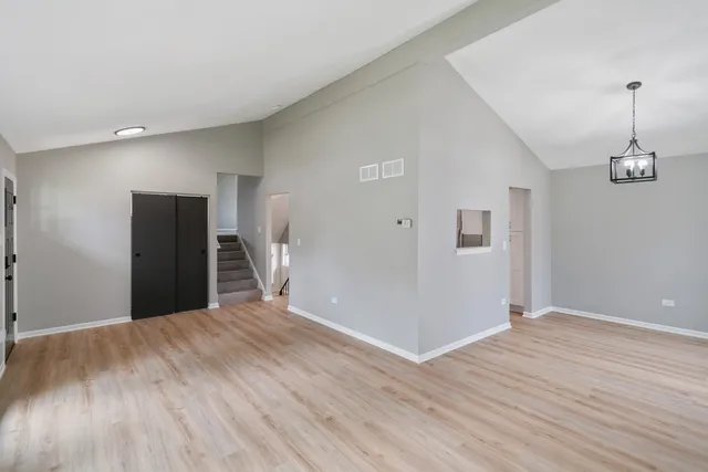 a view of a livingroom with wooden floor and staircase