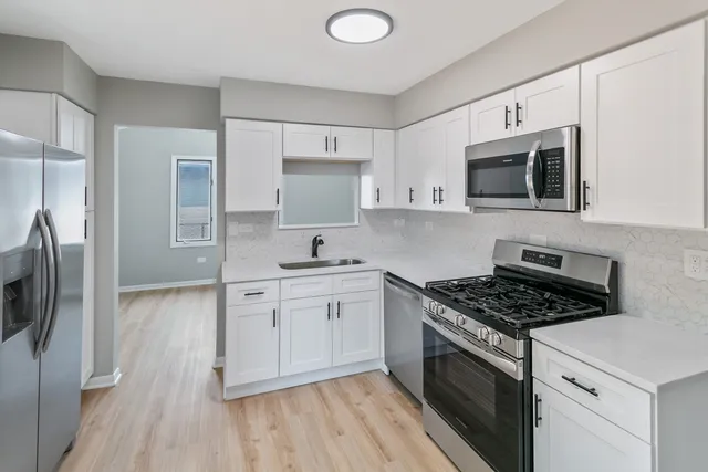 a kitchen with stainless steel appliances granite countertop a stove a sink and a refrigerator