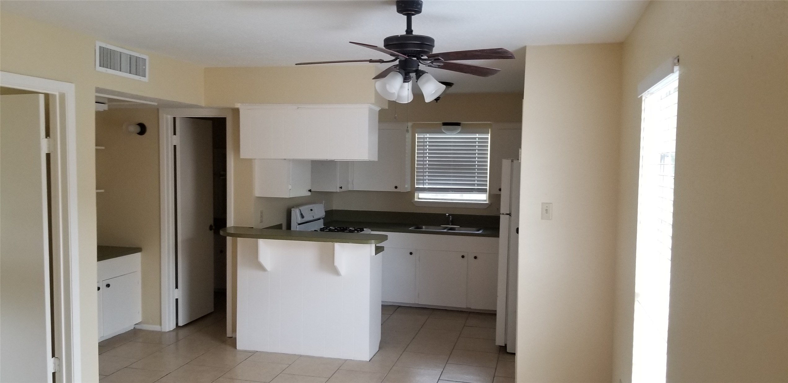 2017 West Sidnor Street, Unit 4 Alvin, TX 77511 - Photo 12 of 13 a kitchen with stainless steel appliances a sink cabinets and a window