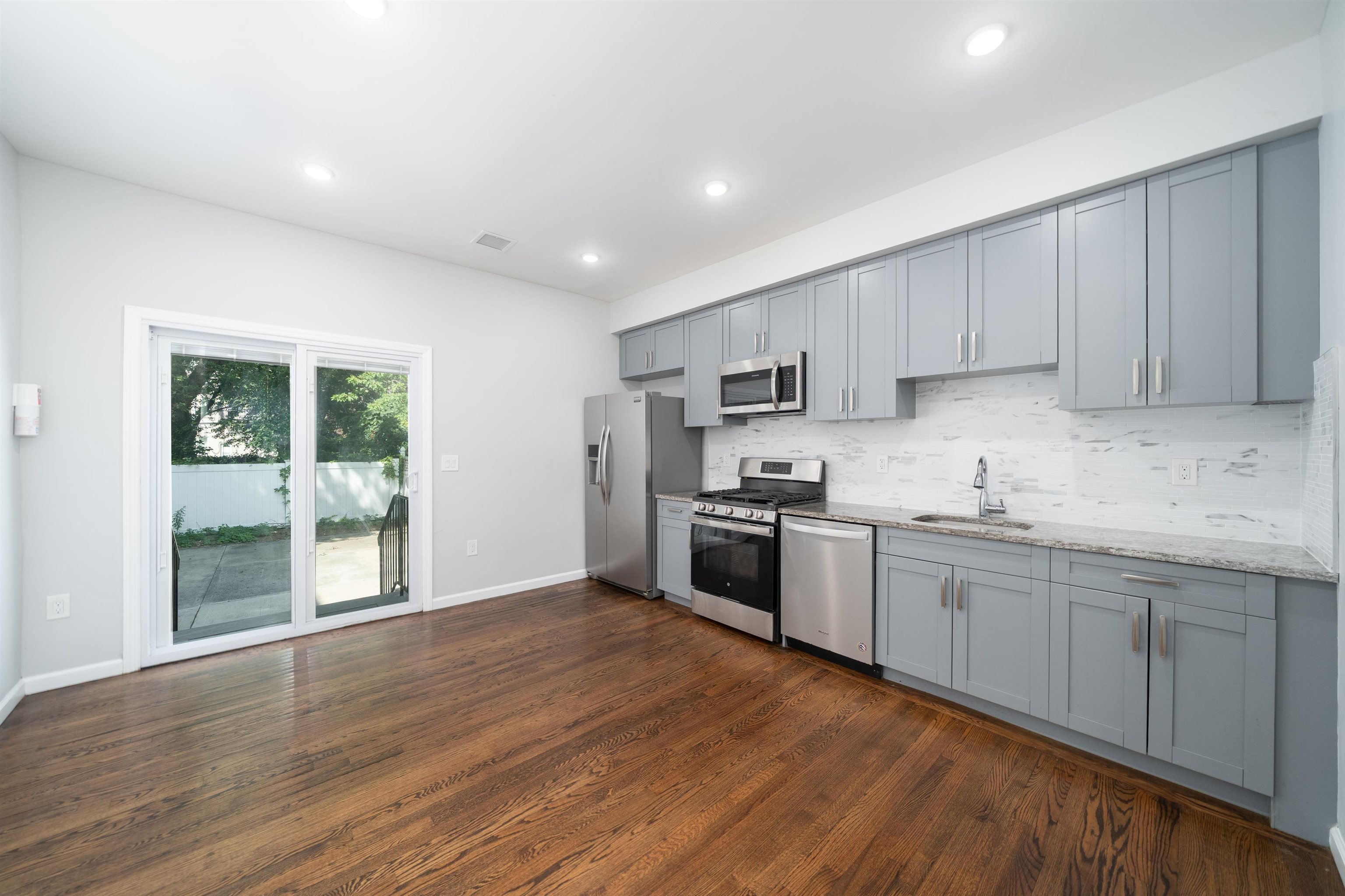 a kitchen with granite countertop a stove top oven sink and cabinets